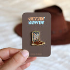 Enamel pin badge of cowboy boots with 'Gettin' Rowdy' text on a card