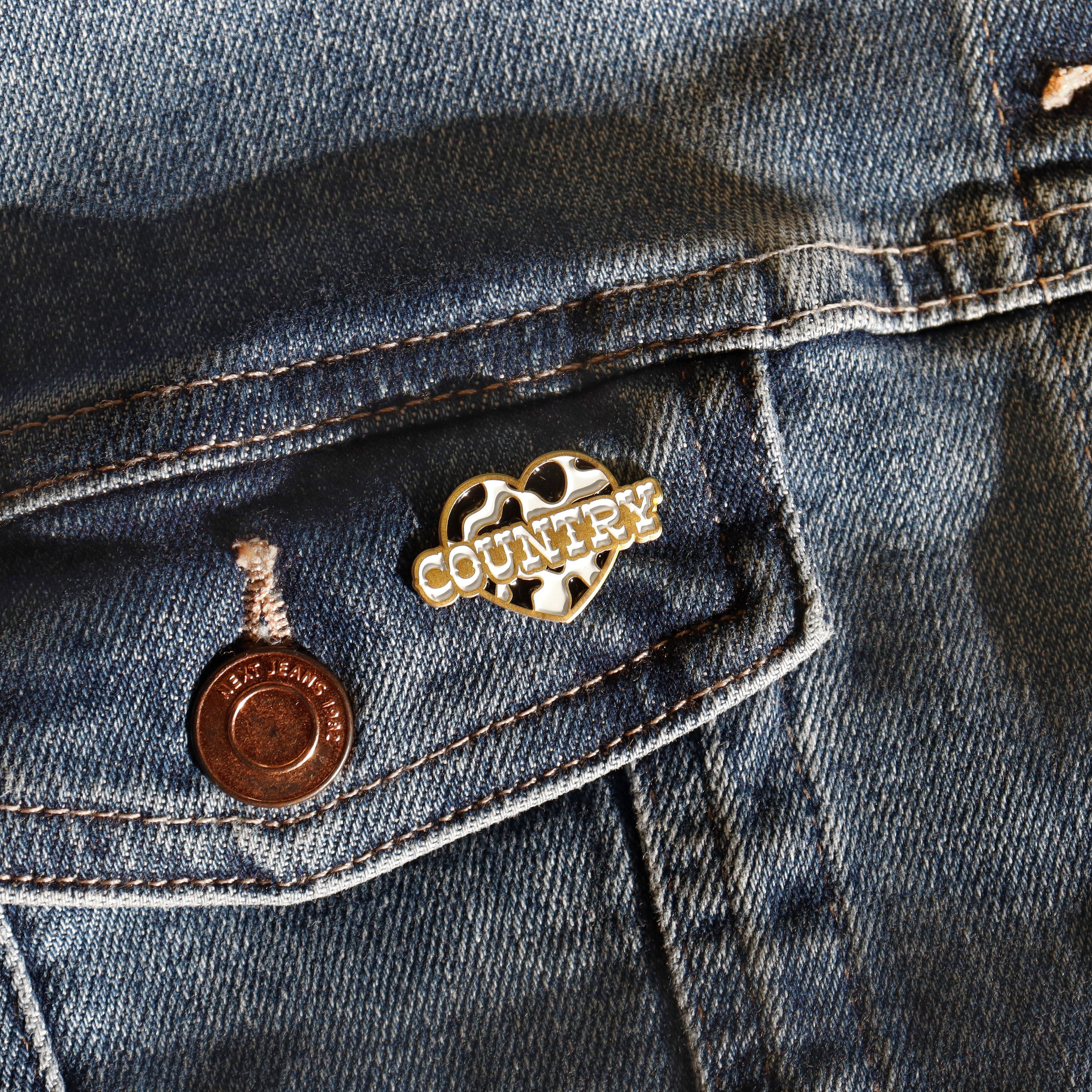 Black and white cow print enamel pin for country music fans