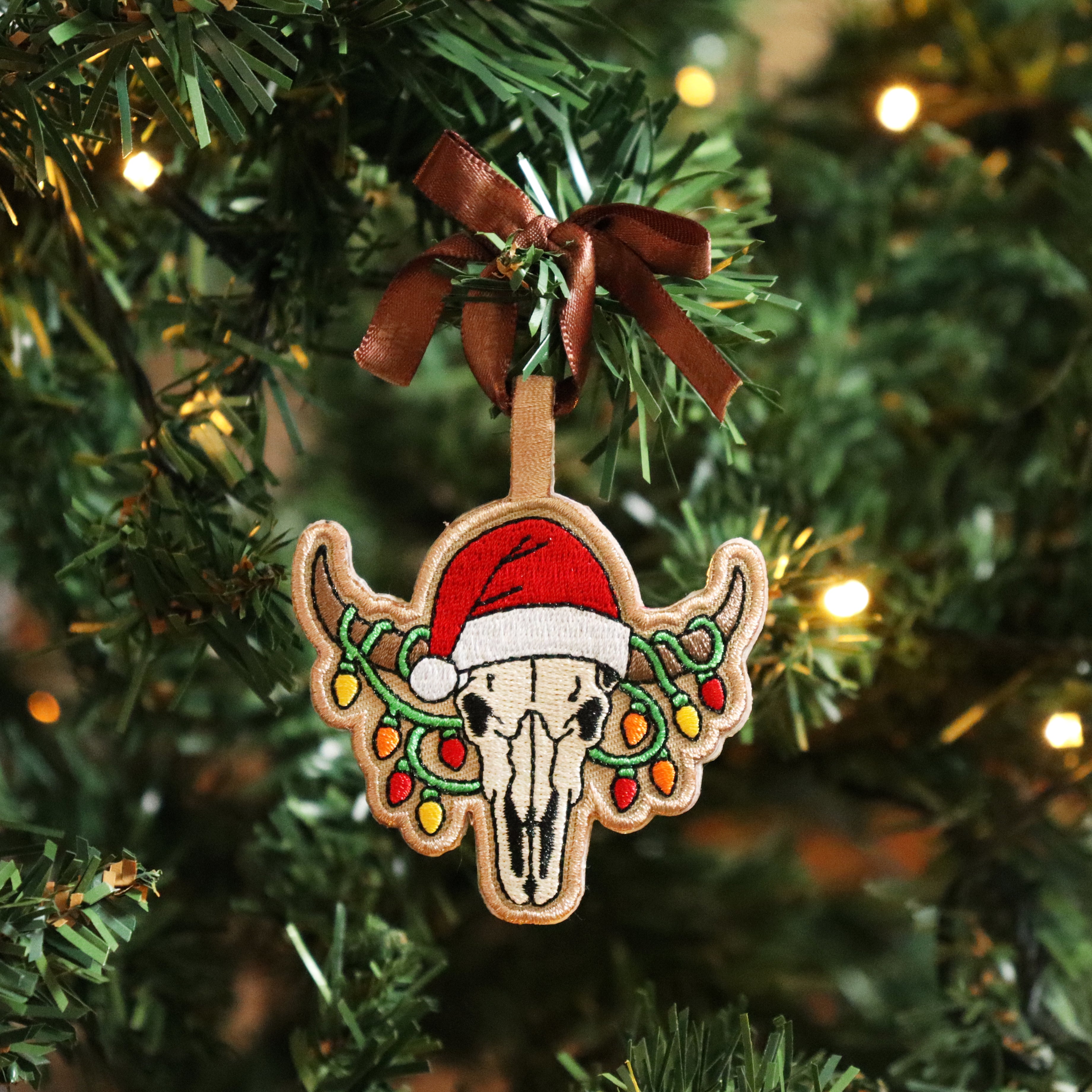 Decorative Christmas ornament with a skull and Santa hat on a Christmas tree.