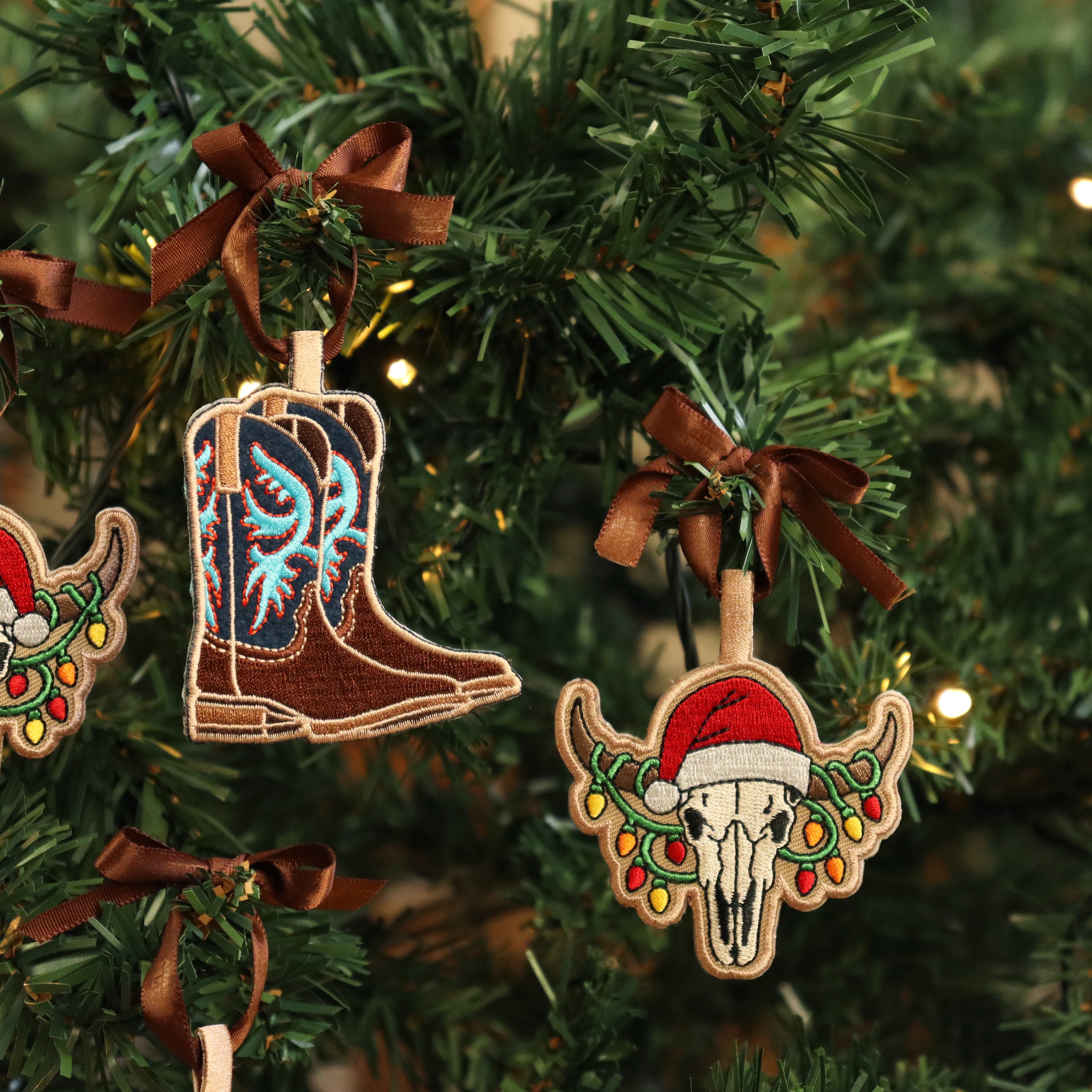Decorative Christmas ornaments on a tree, including a boot and a bull skull with Santa hat.