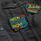 Black jacket with colorful embroidered patches on a dark background