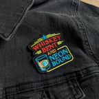 Embroidered patch on a black jacket with colorful text and design.