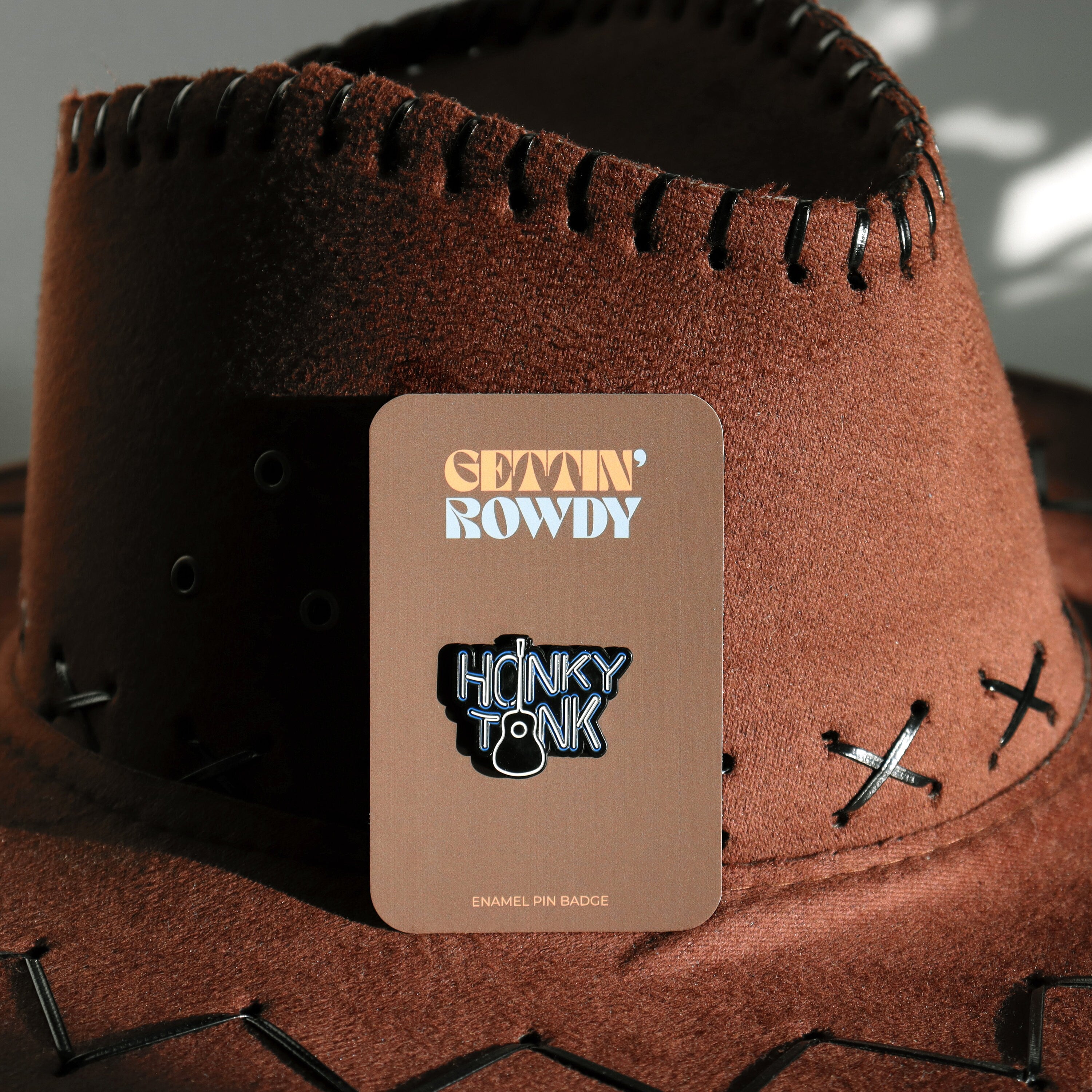 'Honky Tonk' enamel pin badge on a matching card.